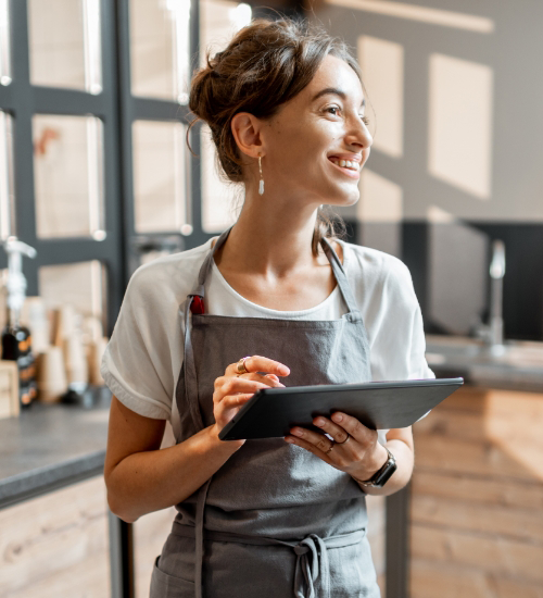 A young kitchen worker uses a tablet for work.